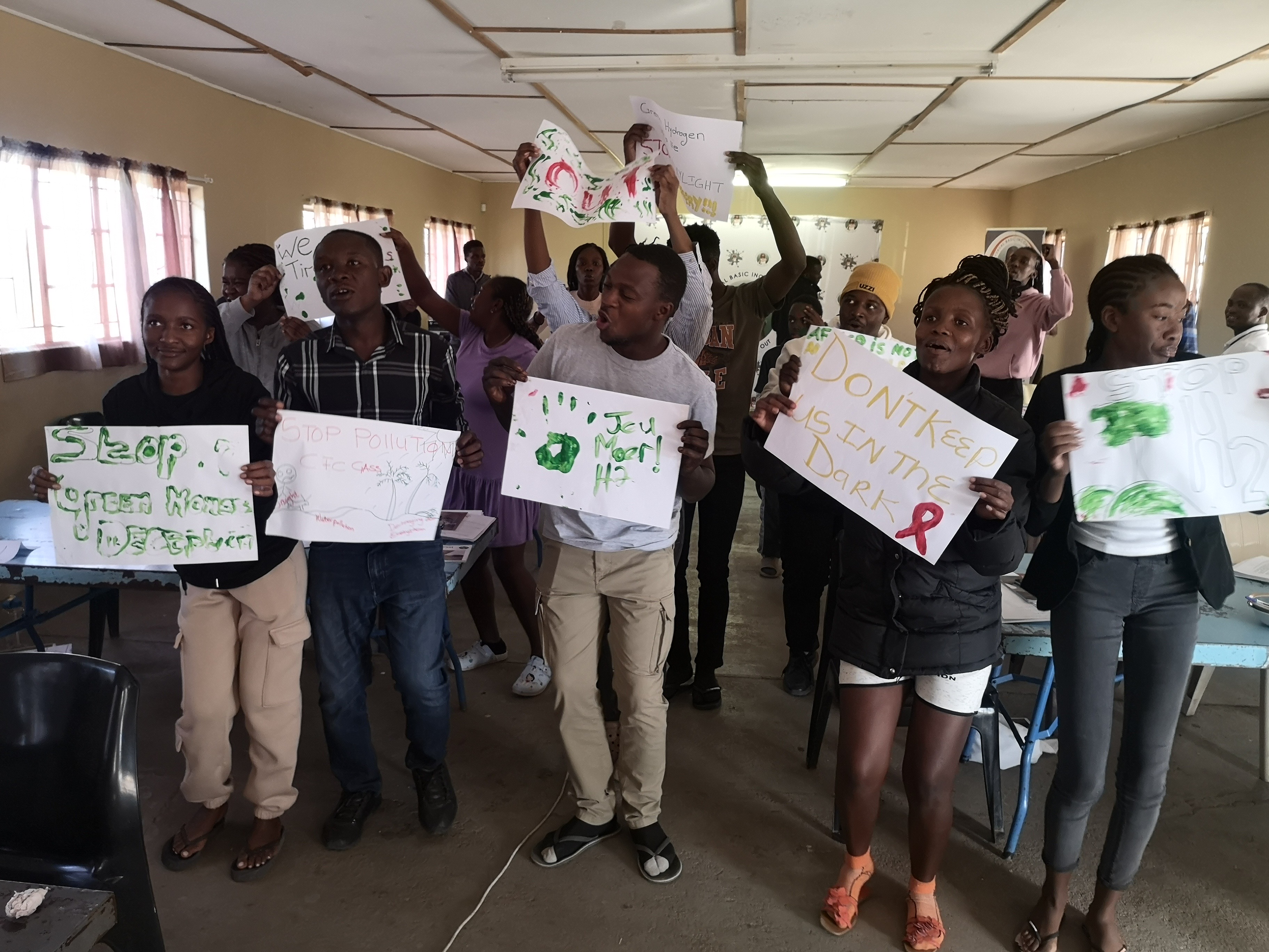 Young ESJT participants holding climate justice posters during a workshop